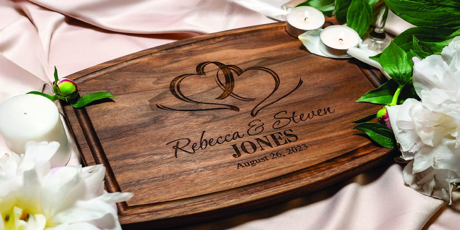 Personalized engraved walnut cutting board with candles and peonies